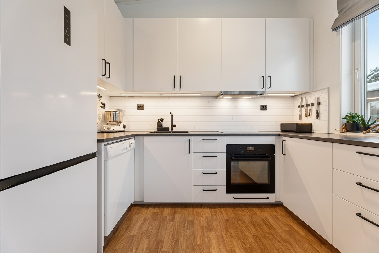 Her får du rikelig med skap- og benkeplass, som gjør matlagingen både praktisk og oversiktlig. Galleribilde