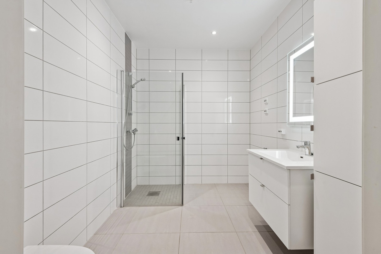 Badet har dusjhjørne og vegghengt toalett Galleribilde