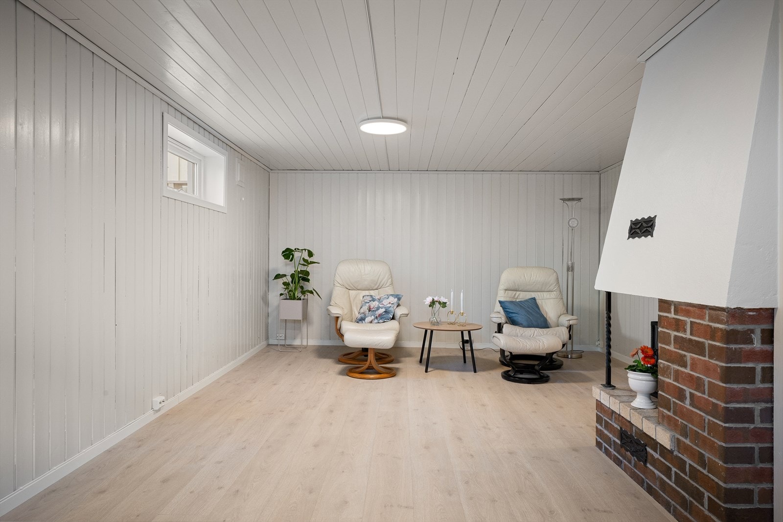 Stor kjellerstue med peis. Pent 1-stavs gulv og tidsriktig malt opp. Rikelig med plass til flere soner møblering gir svært gode bruksmuligheter. (Byggemeldt hobbyrom.) Galleribilde