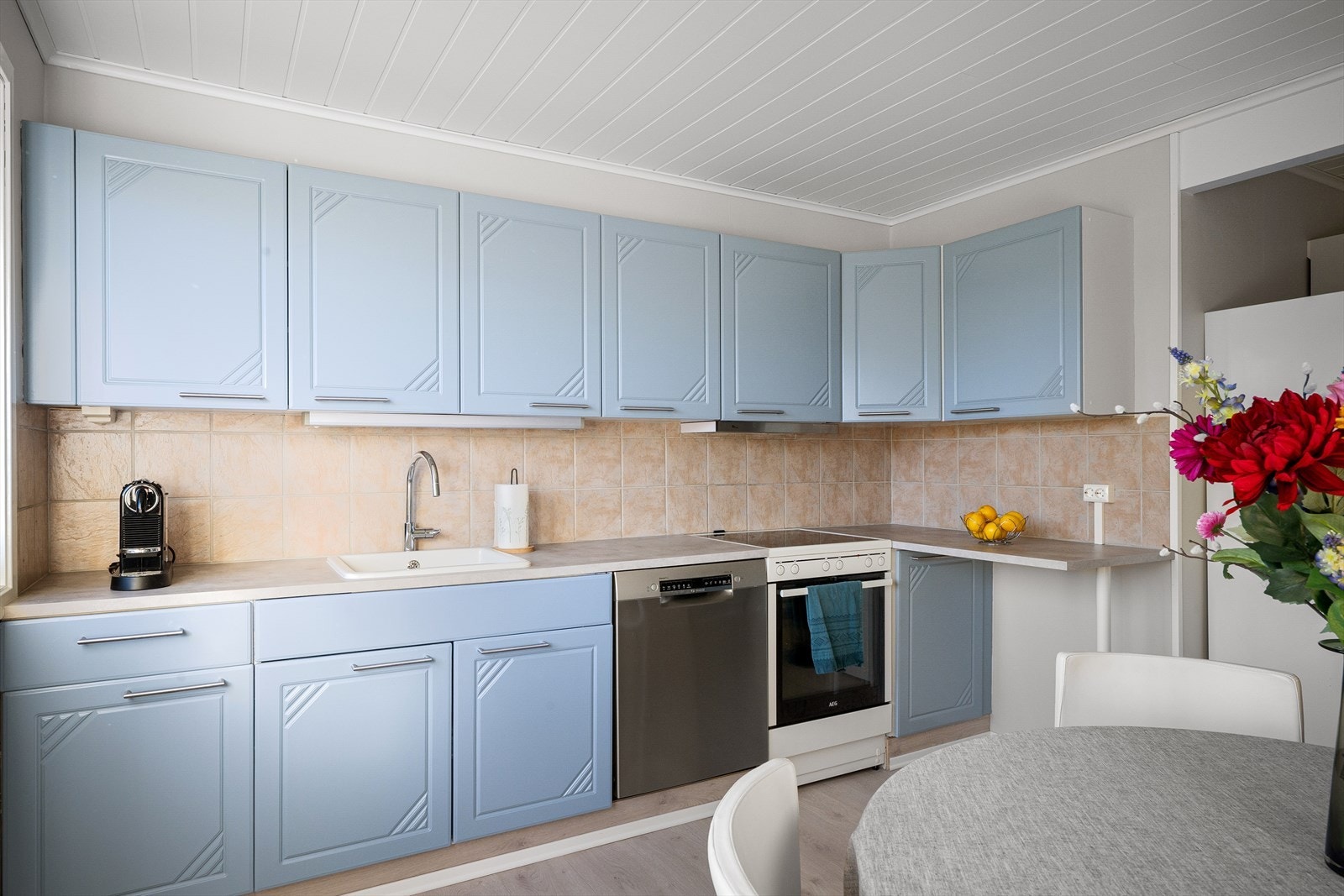 Delvis modernisert kjøkken med mye lagringsplass og naturlig lys for fin atmosfære. Spisebord i midten gjør at en kan samles under matlaging om ungene har lekser, eller en sosial prat. Galleribilde