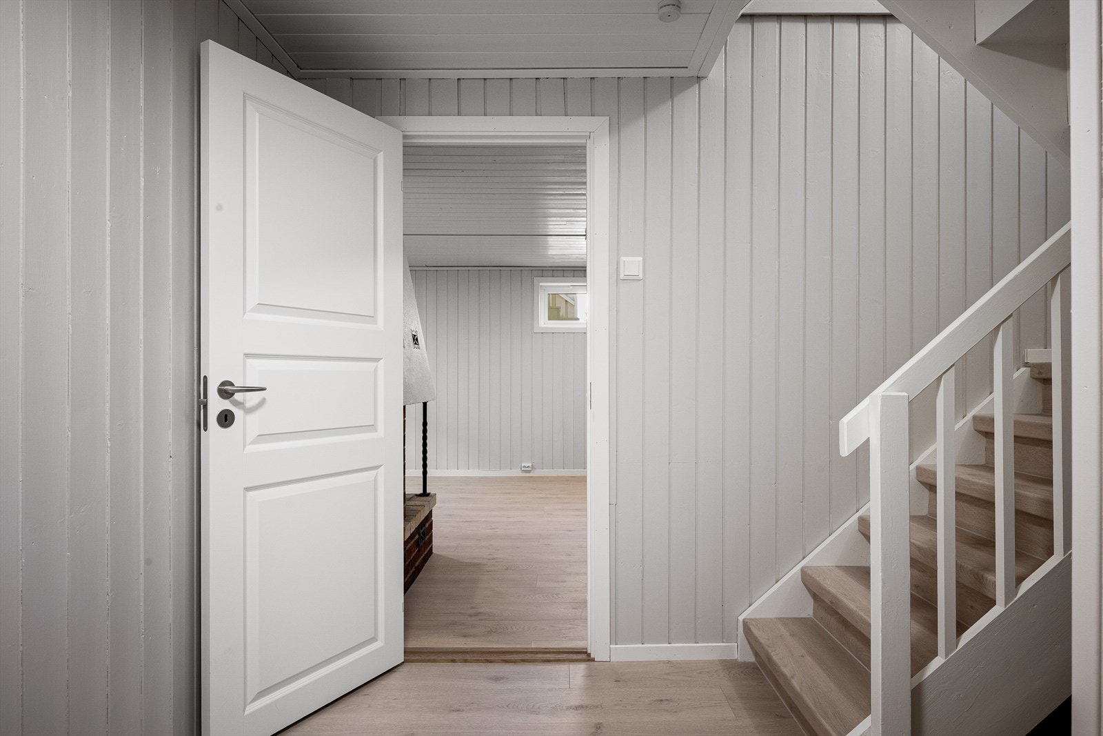 Gang med modernisert trapp ned fra hovedplan. Rom for lagring under trapp. Galleribilde