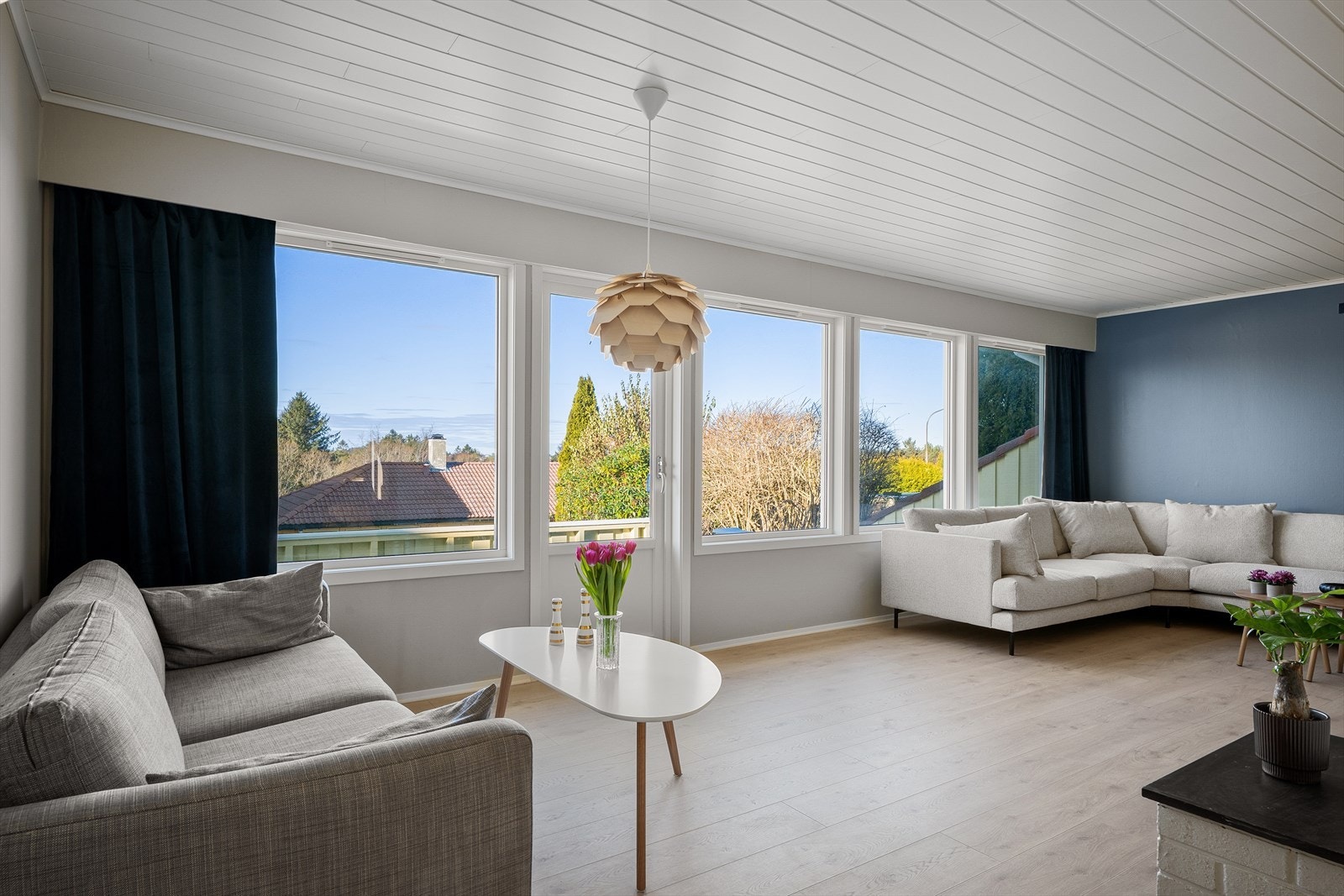 En innbydende stue med moderne gulv og overflater, herlig og luftig utsyn, samt direkte tilgang til stor, solrik terrasse og skjermet hage. Galleribilde