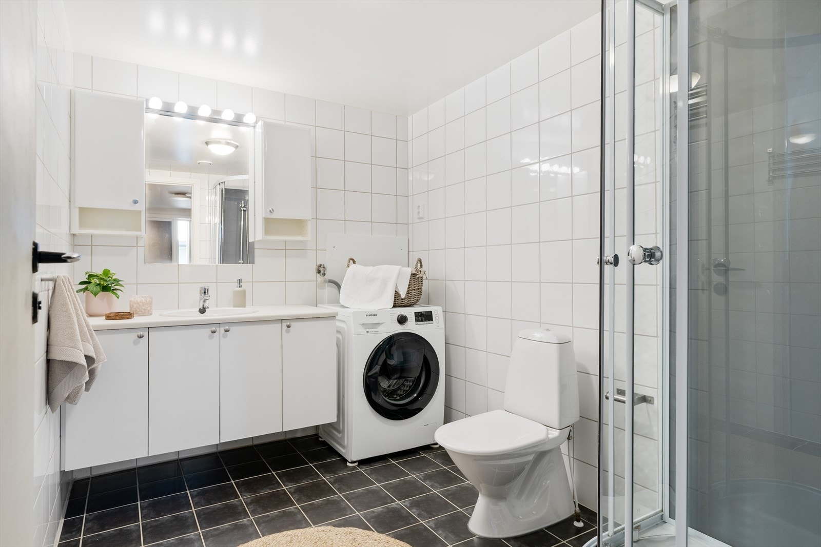 Det 5,9 kvm store badet har flislagte overflater og behagelig gulvvarme. Øvrig innredning består av opplegg for vaskemaskin, toalett, dusjkabinett og en romslig baderomsinnredning med god plass til baderomsartikler. Galleribilde