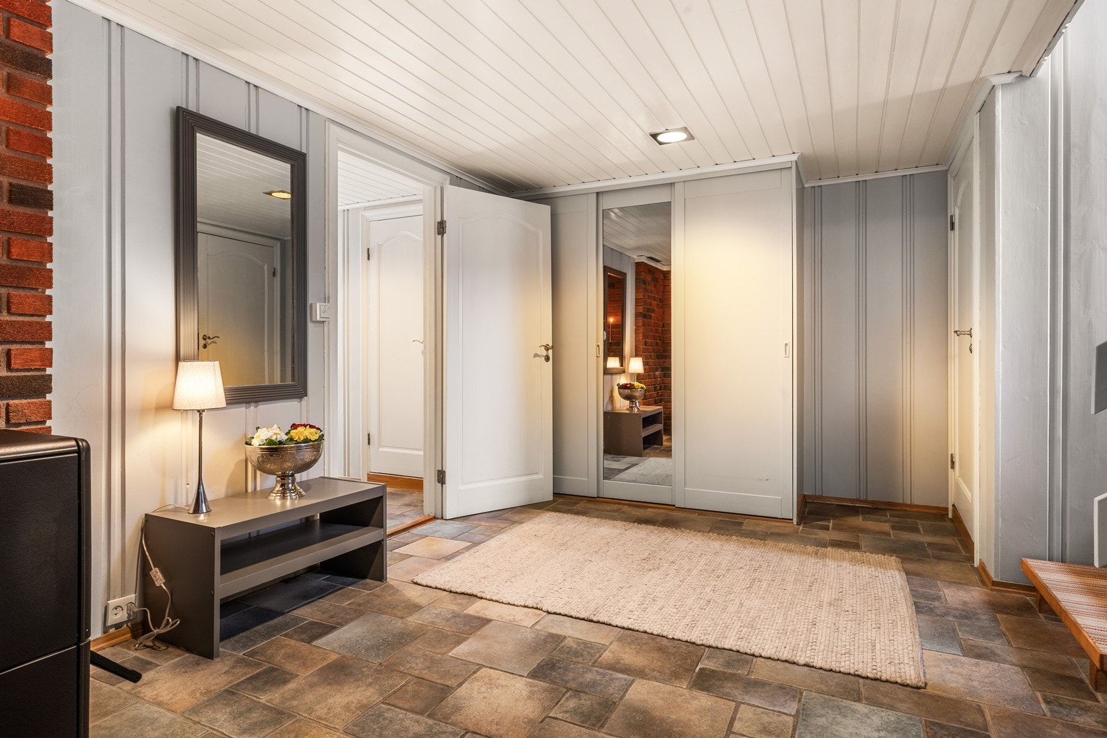 Flislagt gulv gir et praktisk inngangsparti med enkel rengjøring. Skyvedørsgarderobe gir effektiv oppbevaring i entréen. Galleribilde