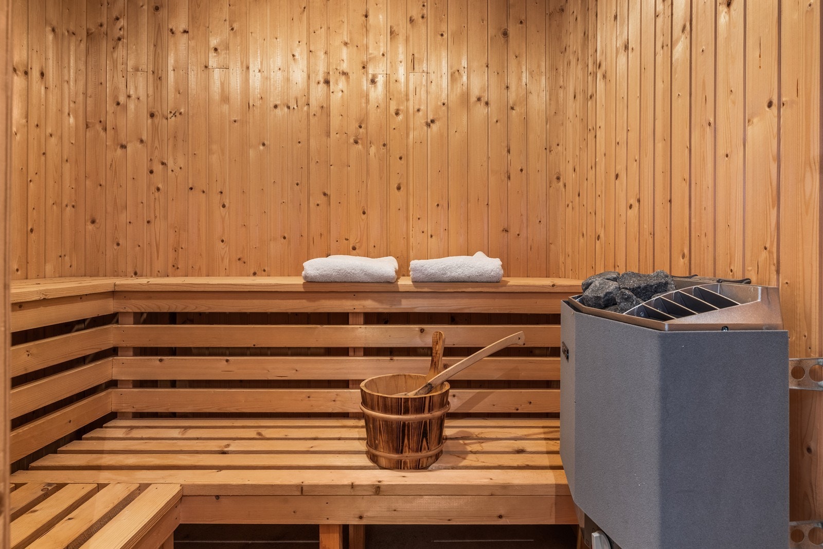 Badstue i kjeller er innredet med benker i tre og badstuovn. Galleribilde