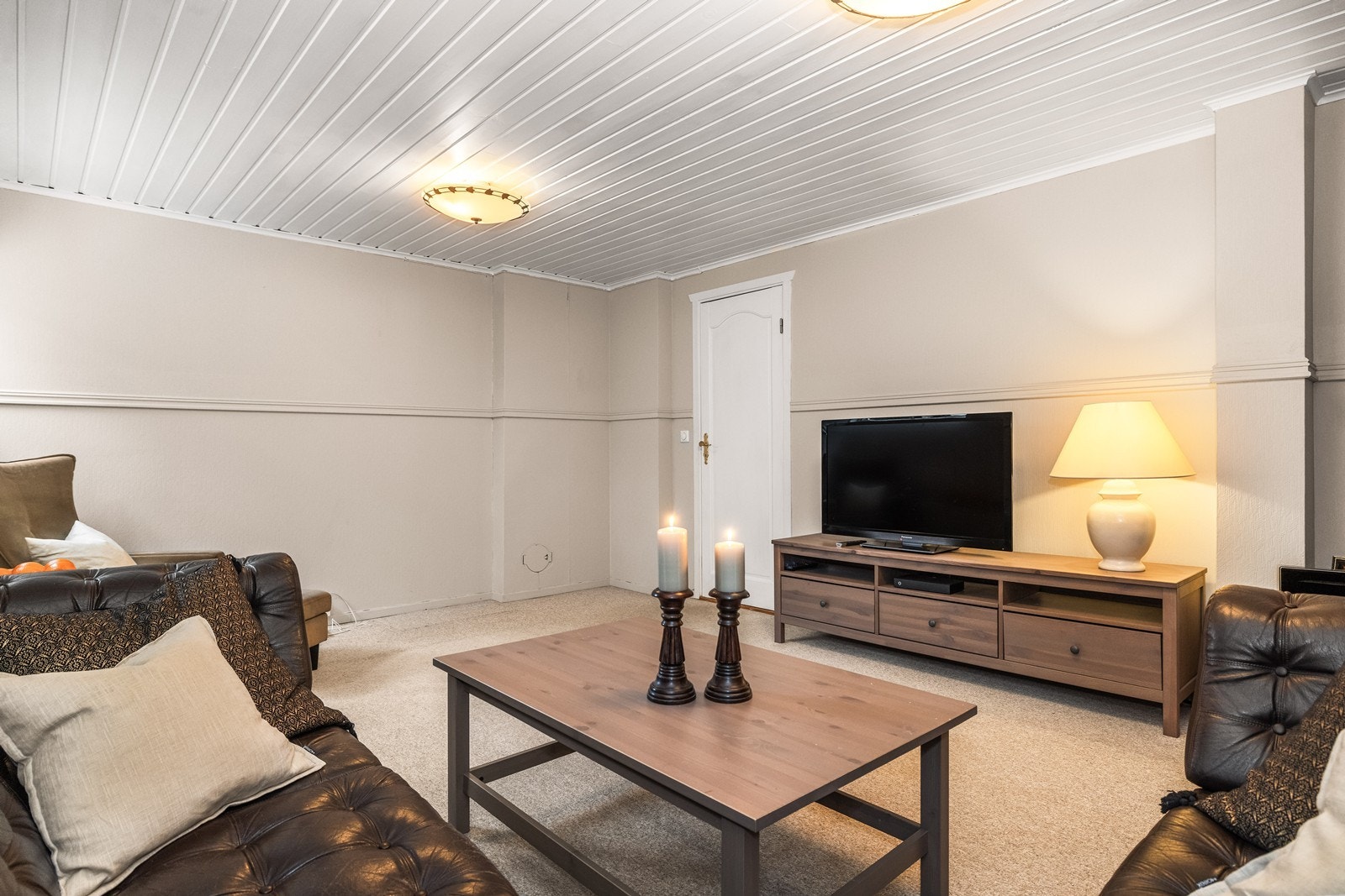 Underetasjen har et koselig oppholdsrom med veggpaneler og teppebelagt gulv. Galleribilde