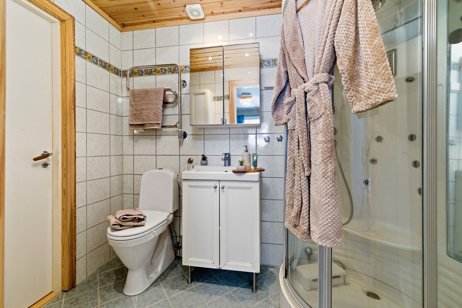 Her er det elektrisk gulvvarme for ekstra komfort, samt servantinnredning og speilskap. Galleribilde