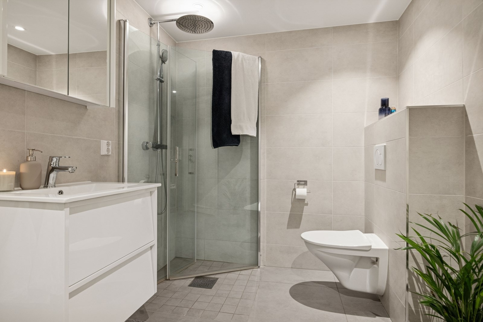 Lekkert og moderne baderom på 6,3 m² fra 2020 som fremstår tidløst og innbydende, med elegante flislagte overflater. Behagelig gulvvarme som gir en eksklusiv og komfortabel følelse. Galleribilde