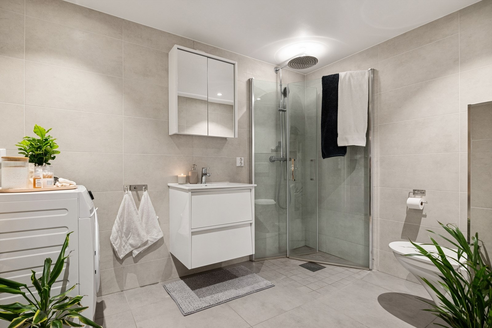 Utstyrt med stilren innredning med servant, vegghengt toalett og dusjvegger i glass som skaper et luftig og moderne rom. Galleribilde