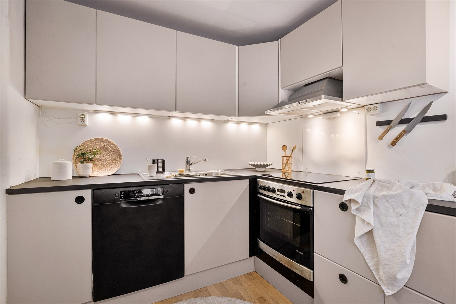 Integrerte hvitevarer som steikeovn, platetopp med induksjon og to kjøleskuffer samt opplegg til oppvaskmaskin. Galleribilde