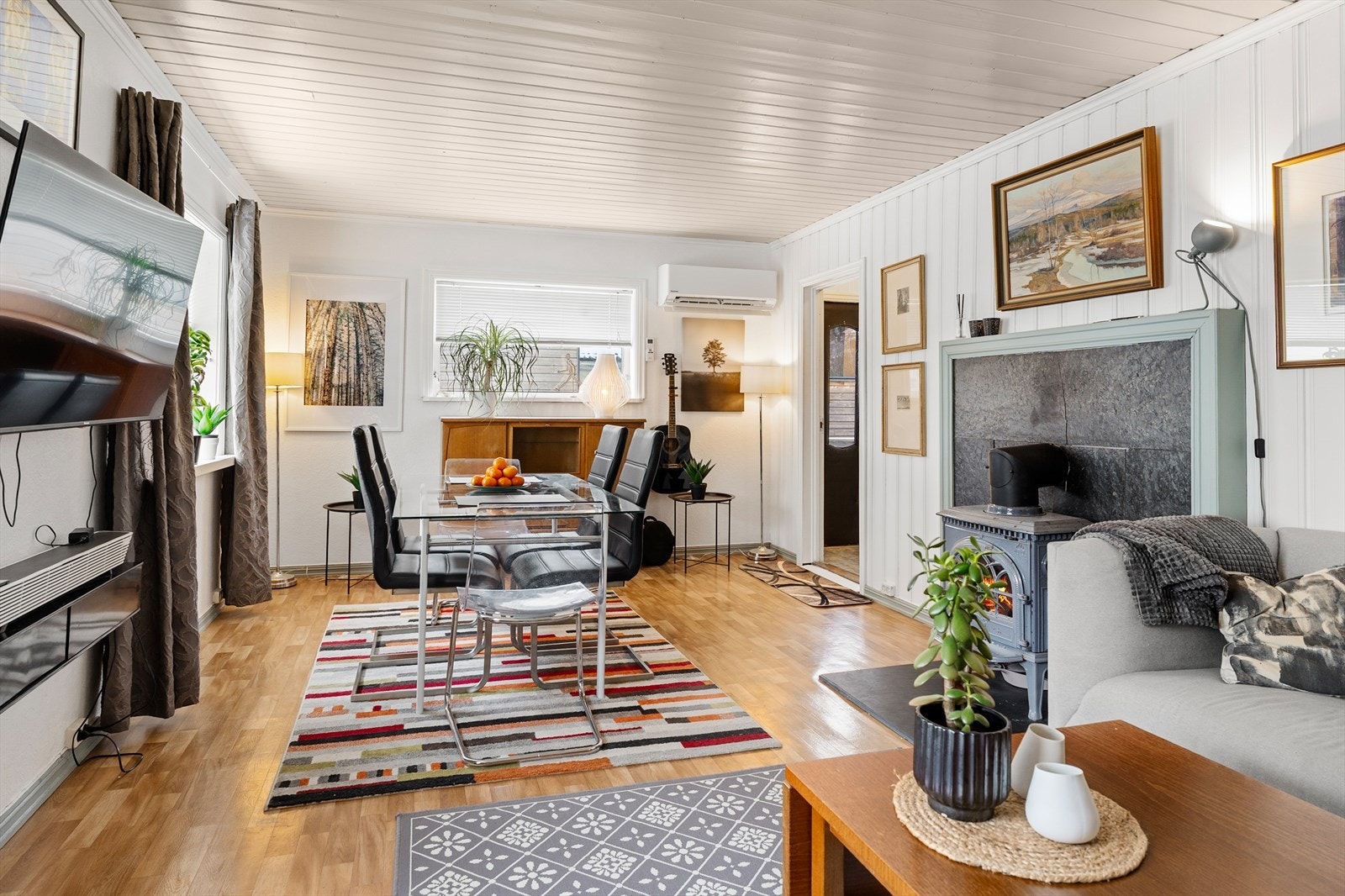 Boligen har en lys og romslig stue med plass til både sofagruppe og spisebord Galleribilde