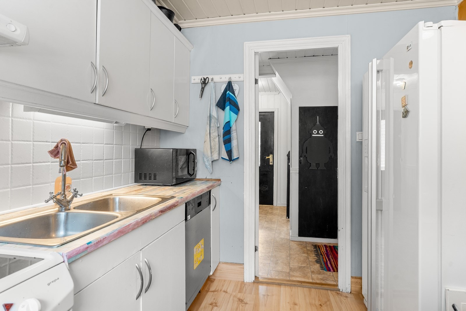 Kjøkkenet har innredning med slette fronter og laminat benkeplate Galleribilde