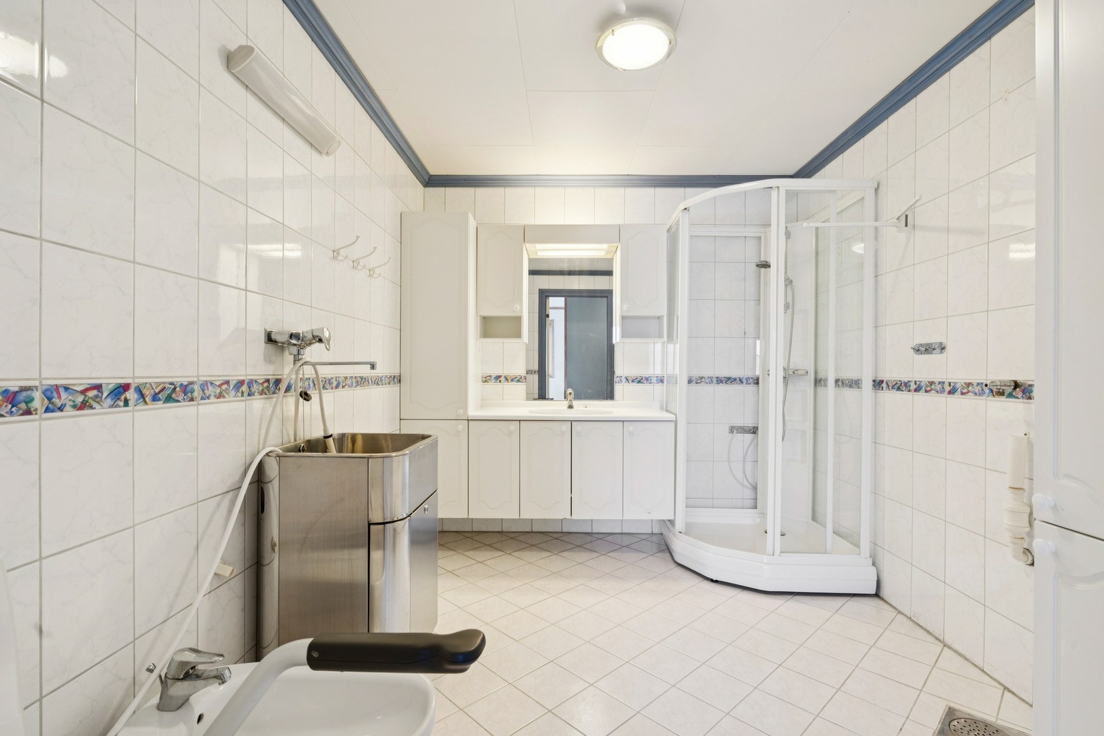 Badet er utstyrt med dusjkabinett og en praktisk utslagsvask i stål. Galleribilde