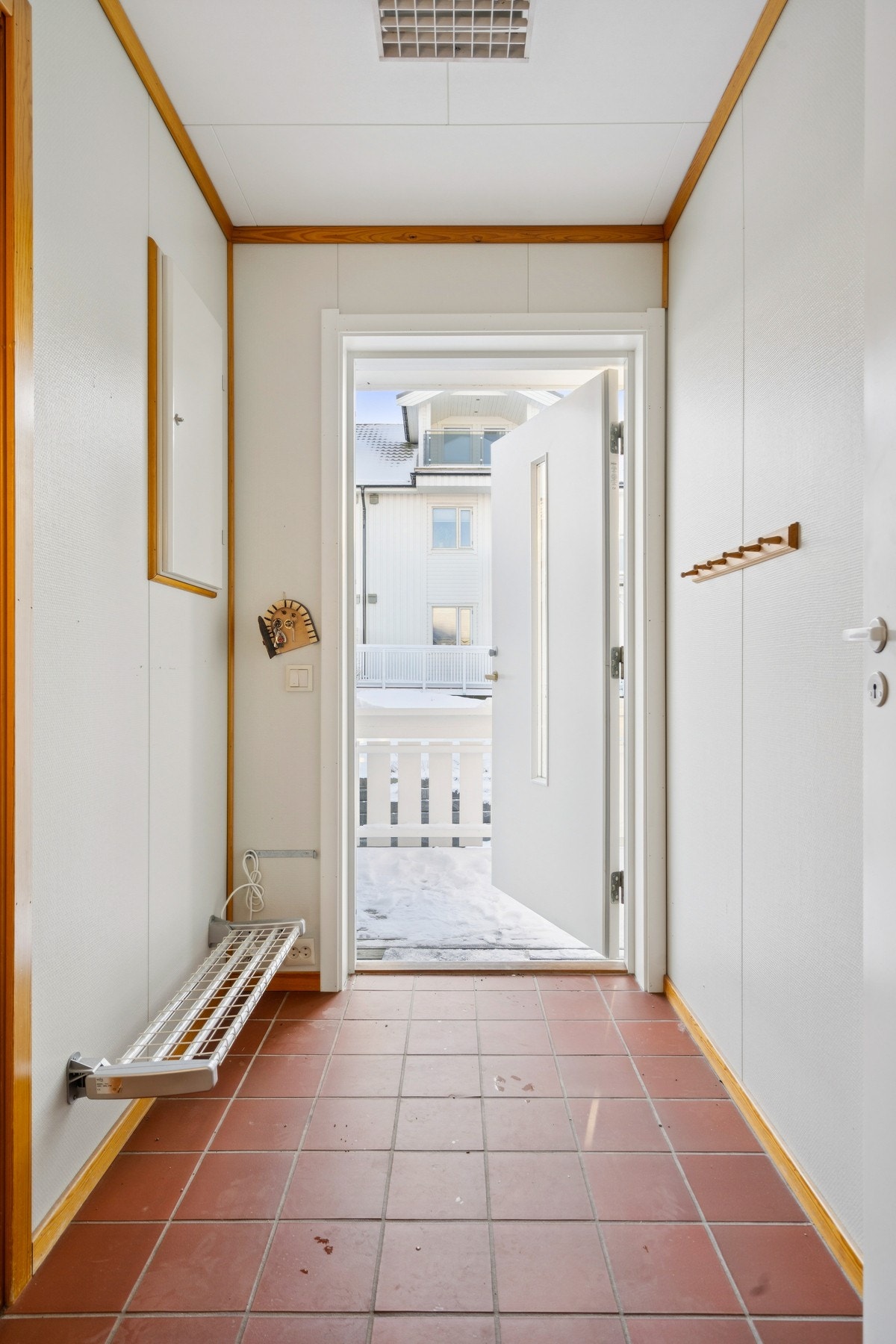 Inngangsparti med flislagt gulv og plass til oppbevaring av yttertøy. Galleribilde