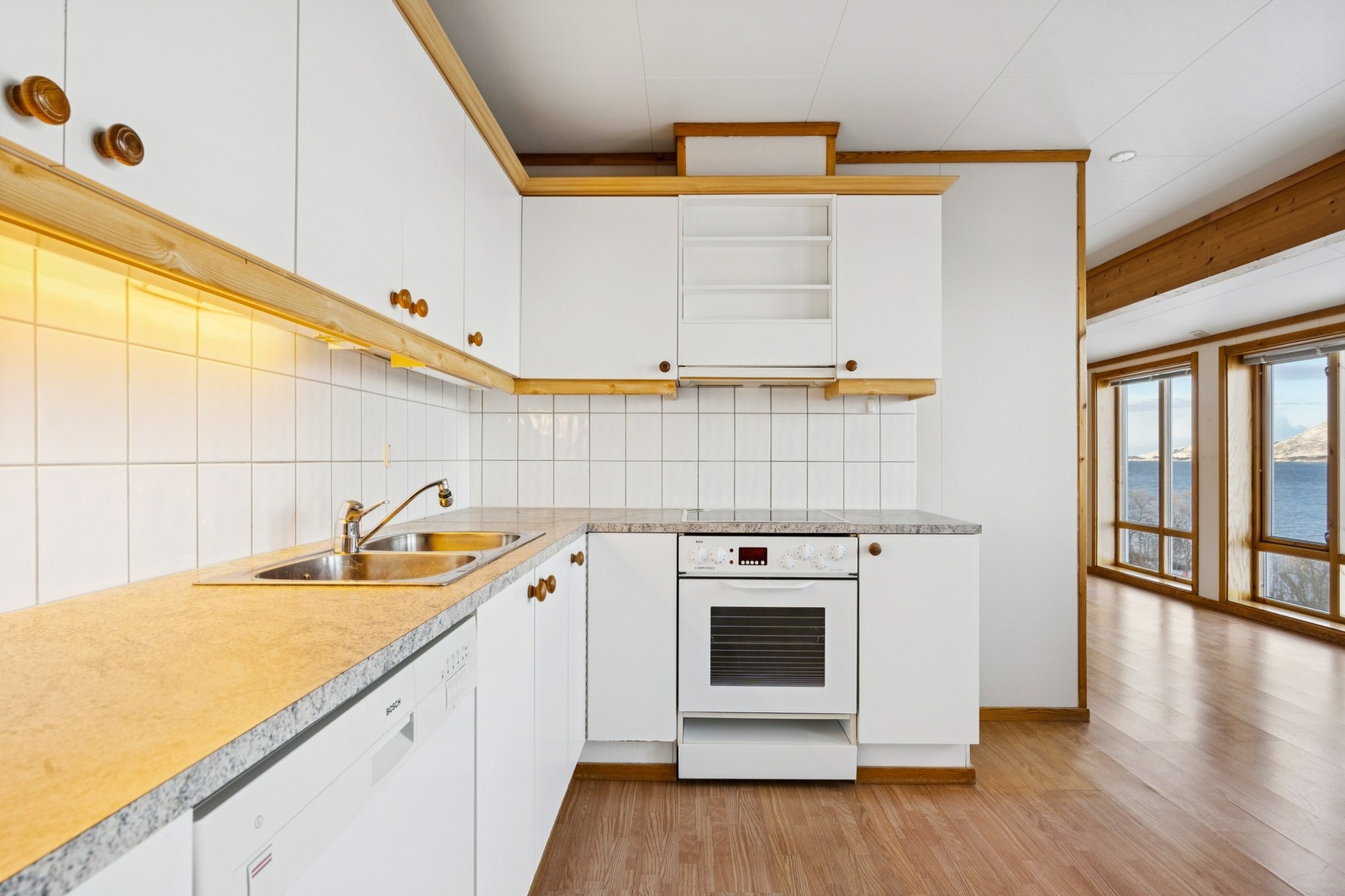 Kjøkkeninnredningen har hvite, glatte fronter og laminat benkeplate. Galleribilde