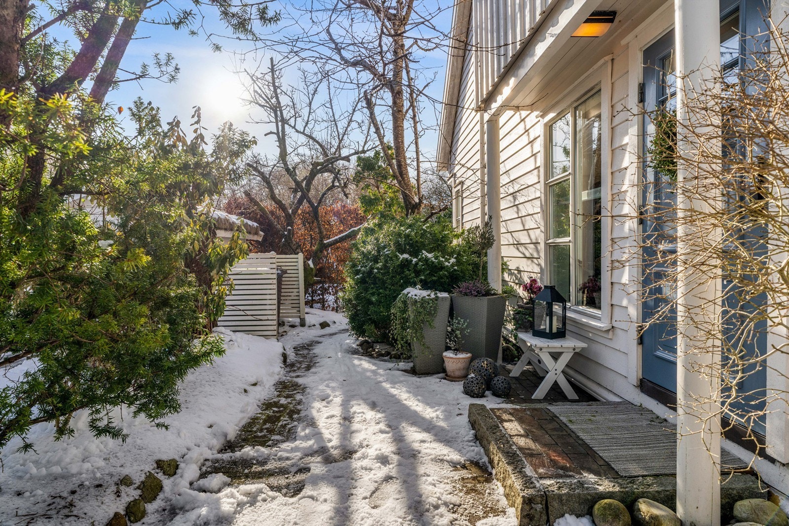 Inngangsparti, med steinbelagt uteareal og passasje inn til hage/uteareal Galleribilde