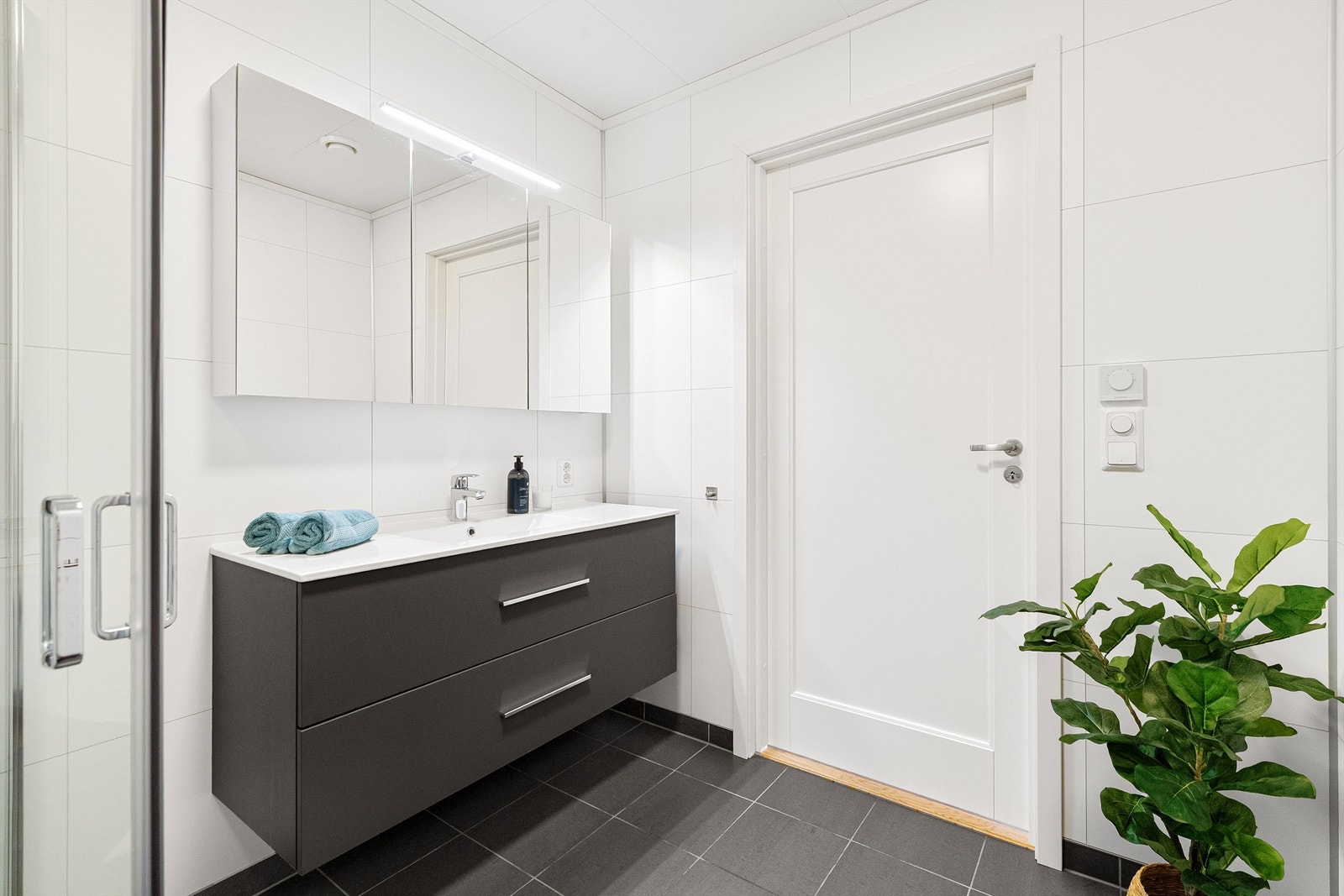 Badet er utstyrt med baderomsinnredning, vegghengt toalett og dusjhjørne Galleribilde