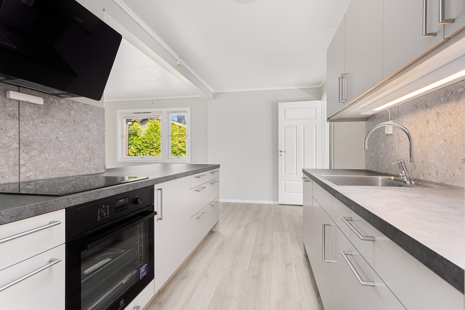 Integrerte hvitevarer som oppvaskmaskin, komfyr/koketopp, vannstoppsystem og komfyrvakt. Galleribilde