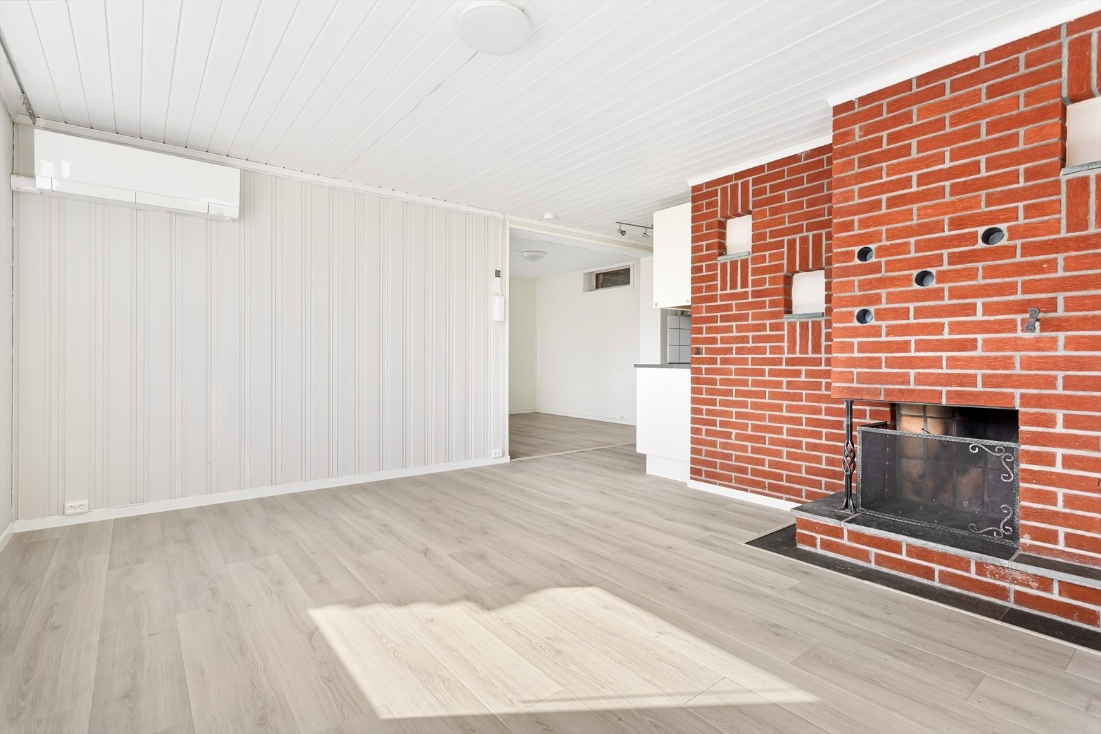 Det er laminat på gulv og malte panelplater på vegg. Galleribilde