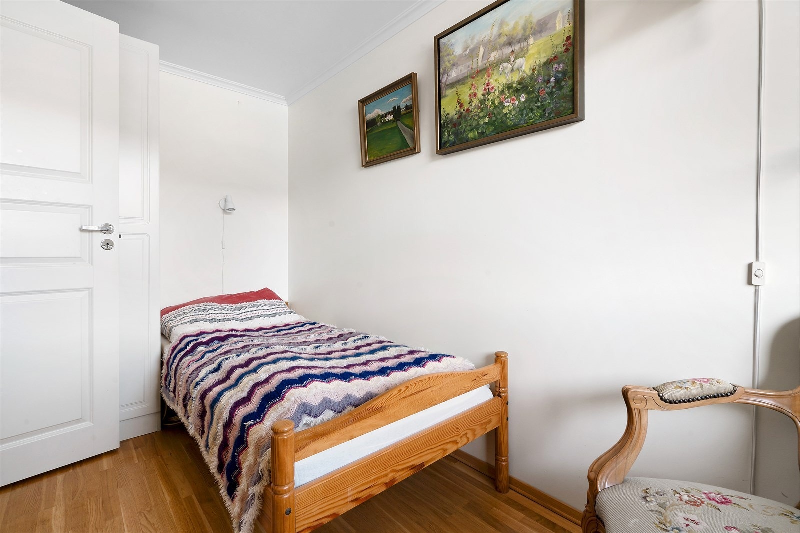 Soverom 2 har plass til seng, nattbord og garderobe. Eik parkett på gulv og malt gips på vegger. Galleribilde