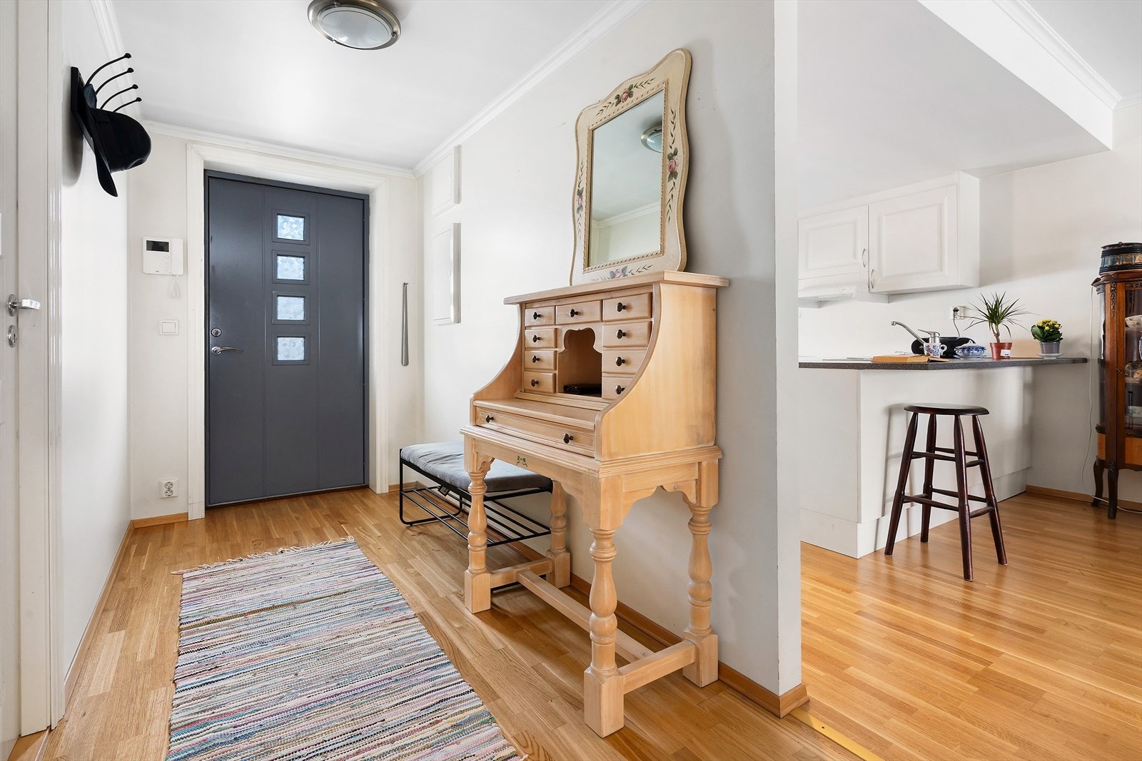 Lys entré/gang med rom for garderobeløsning. God plass til sko og yttertøy. Dørtelefon med video. Galleribilde