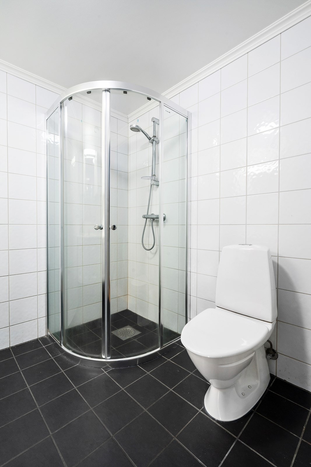 Badet er utstyrt med dusjhjørne med veggmontert dusj og toalett. Opplegg for vaskemaskin. Galleribilde