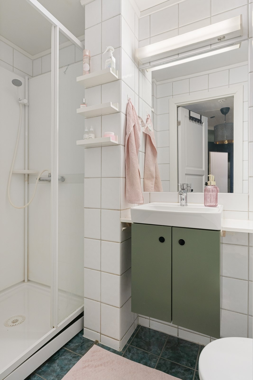 Flislagt bad med praktisk dusjkabinett, toalett og servant. Galleribilde