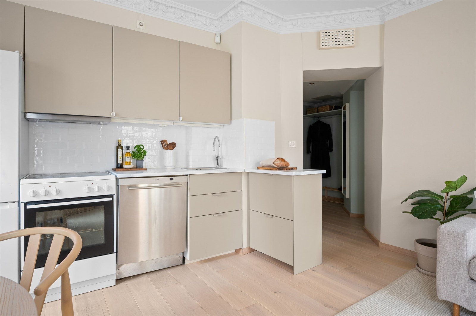 Kjøkkenet fra Ikea er både stilrent og praktisk, og ligger i åpen løsning mot stuen. Innredningen har nye, glatte fronter fra 2024 og benkeplate i heltre med kontaktplast. Galleribilde