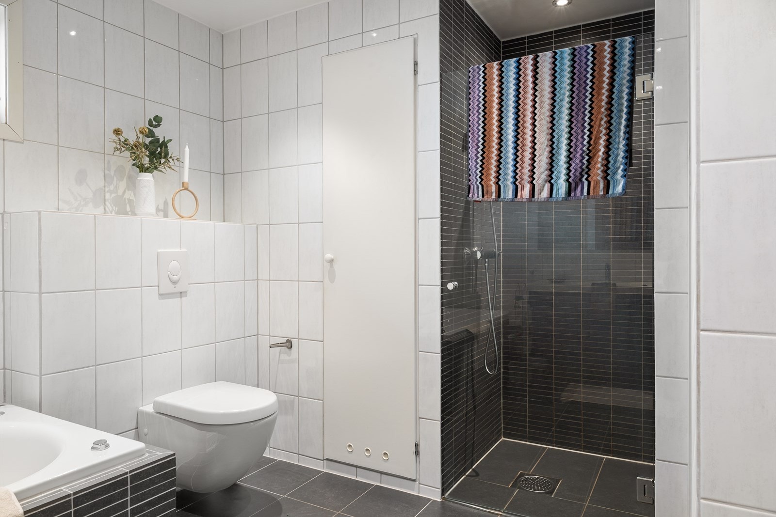 Praktisk og stilren dusjsone med glassdør og moderne flisvalg. Galleribilde