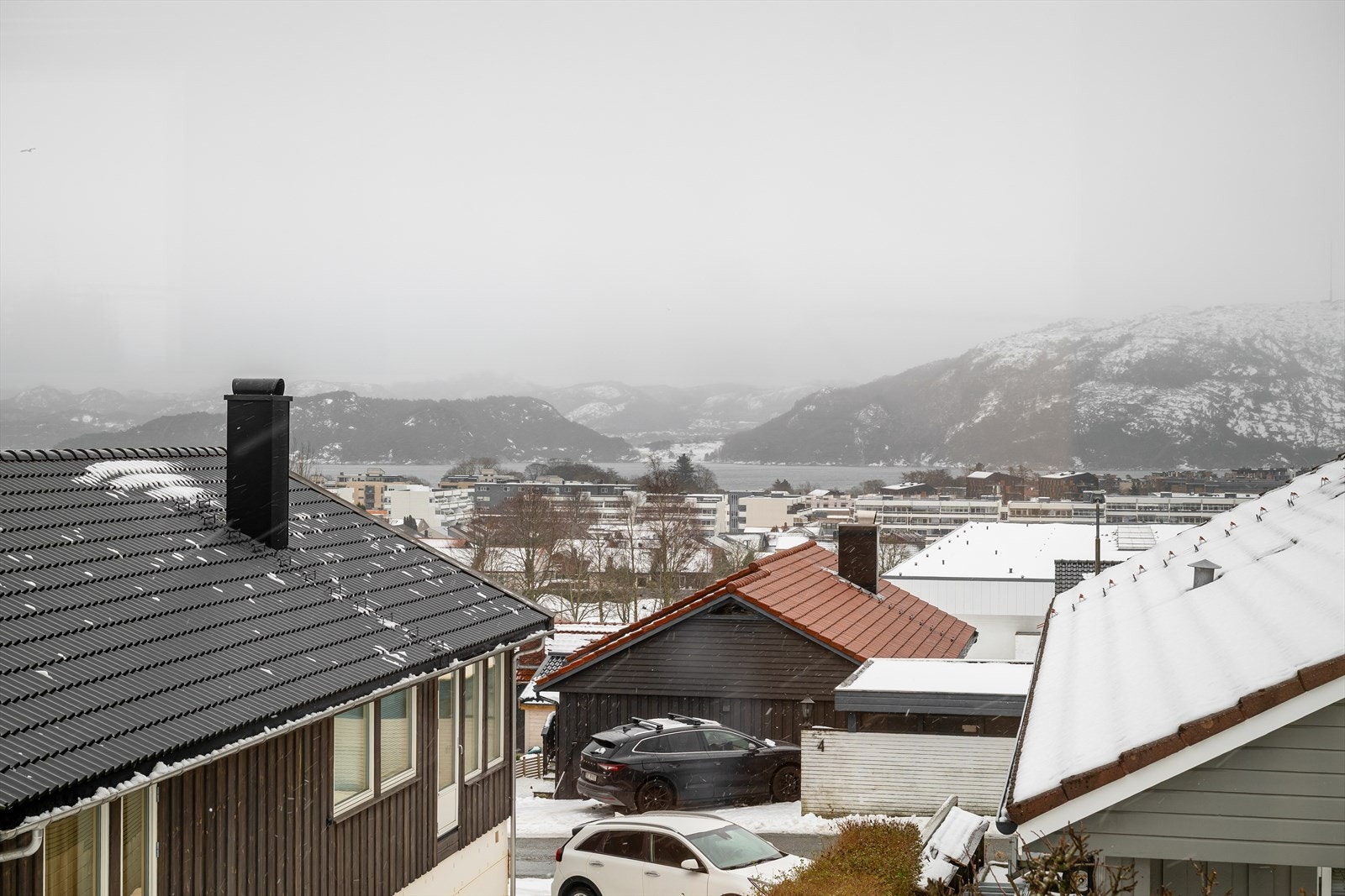 Flott utsikt over nærområdet med fjord og fjell i bakgrunnen. Galleribilde