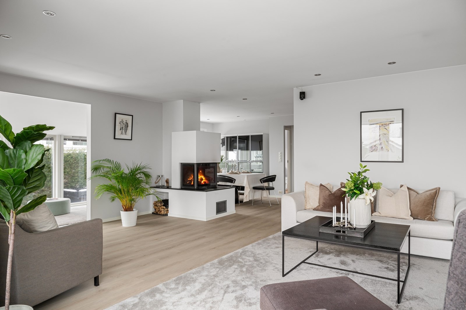 Innbydende oppholdsrom med åpen løsning mot spiseplass og flott peis som skaper lun stemning. Galleribilde