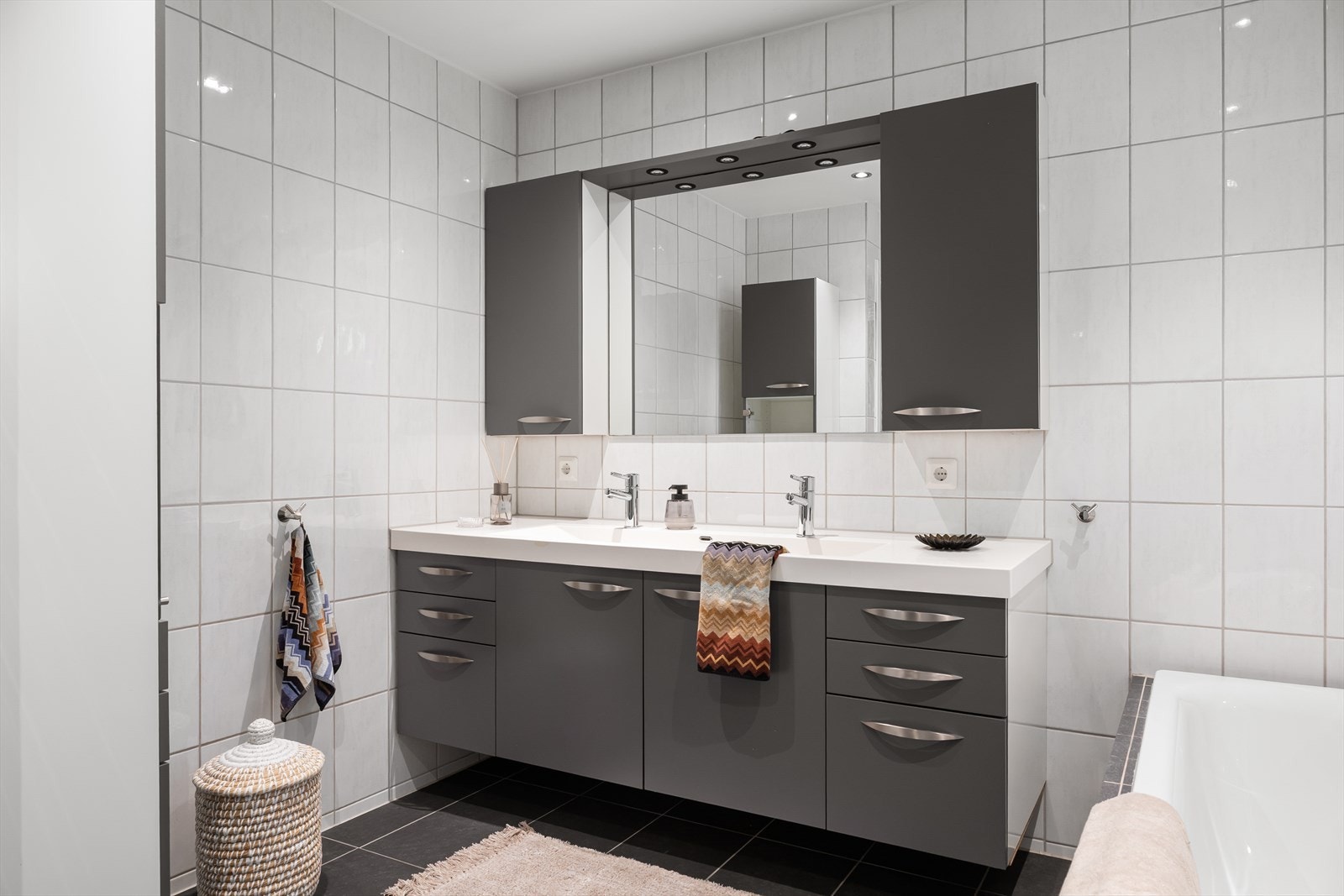 Dobbel servant og rikelig med skapplass. Helhetlig flisvalg og downlights i himling gir et moderne uttrykk. Galleribilde