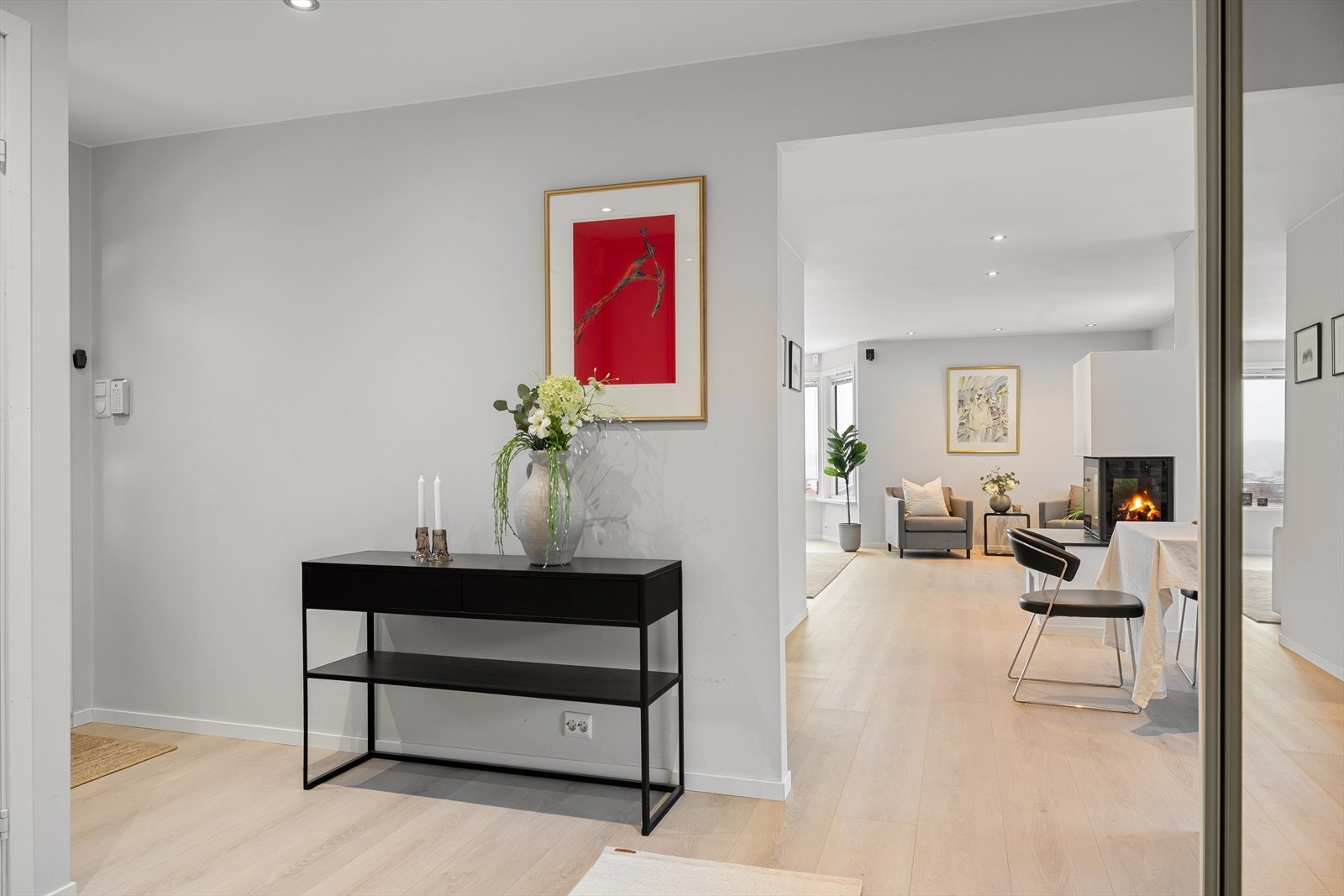 Inngangsparti med gjennomgående parkett og åpen tilknytning til oppholdsrommene. Galleribilde