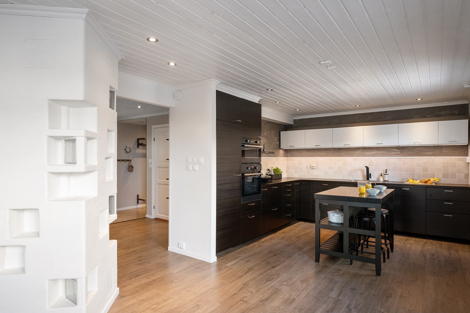 Kjøkkenet har en stilren innredning i mørke og hvite toner, med glatte fronter som gir et moderne preg. Galleribilde