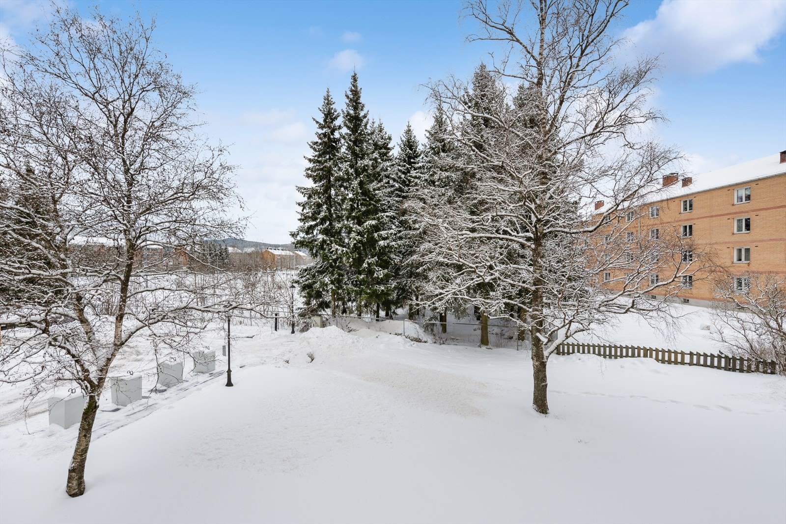 Tomten er opparbeidet med beplantning, plen og områder for lek og opphold for alle beboere. Galleribilde