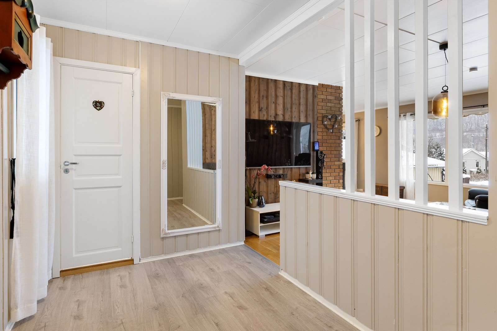 En lav romdeler skiller gangen fra stuen og skaper en naturlig soneinndeling. Galleribilde