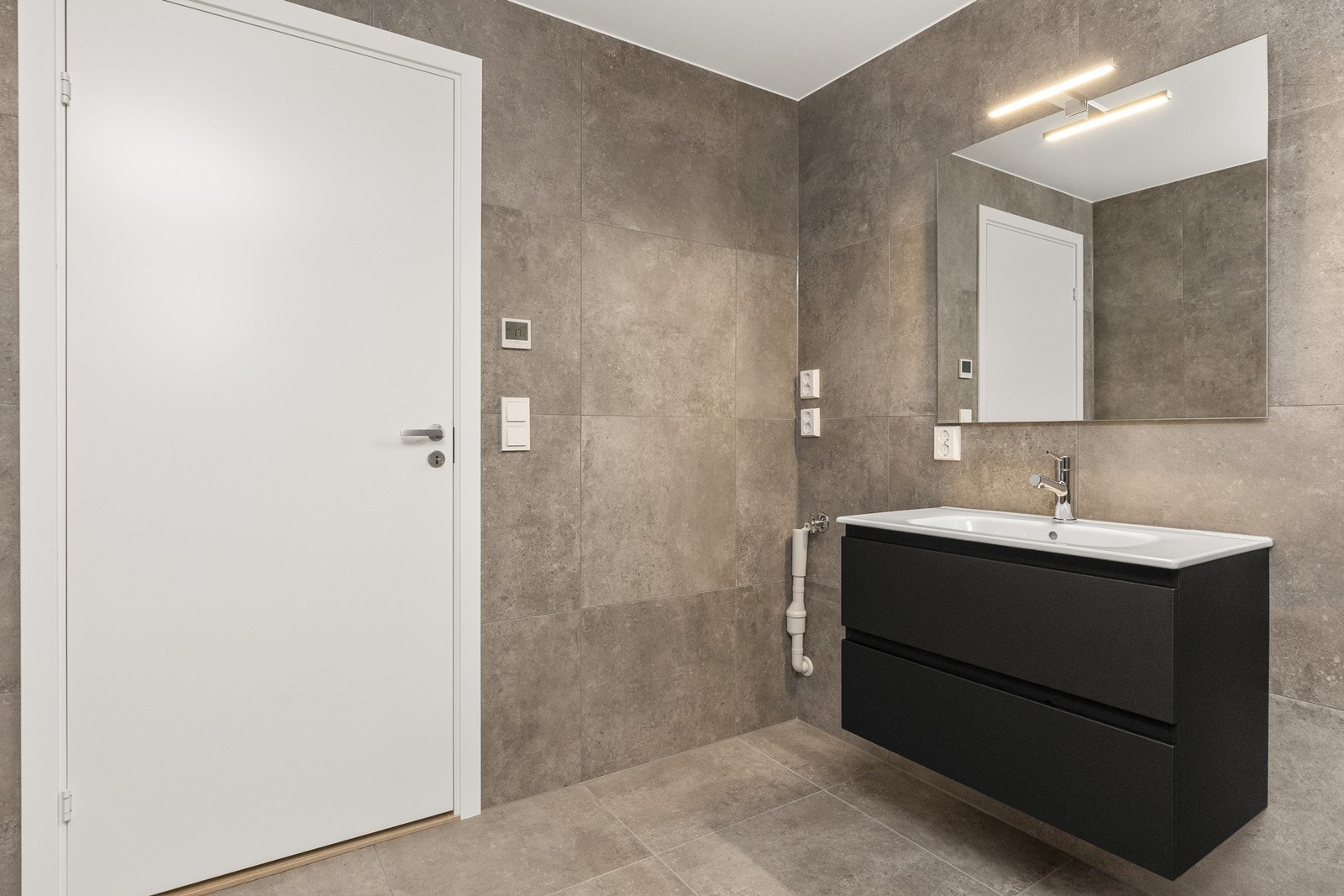 Rommet er utstyrt med vegghengt toalett og et dusjhjørne med innfellbare glassdører. Galleribilde