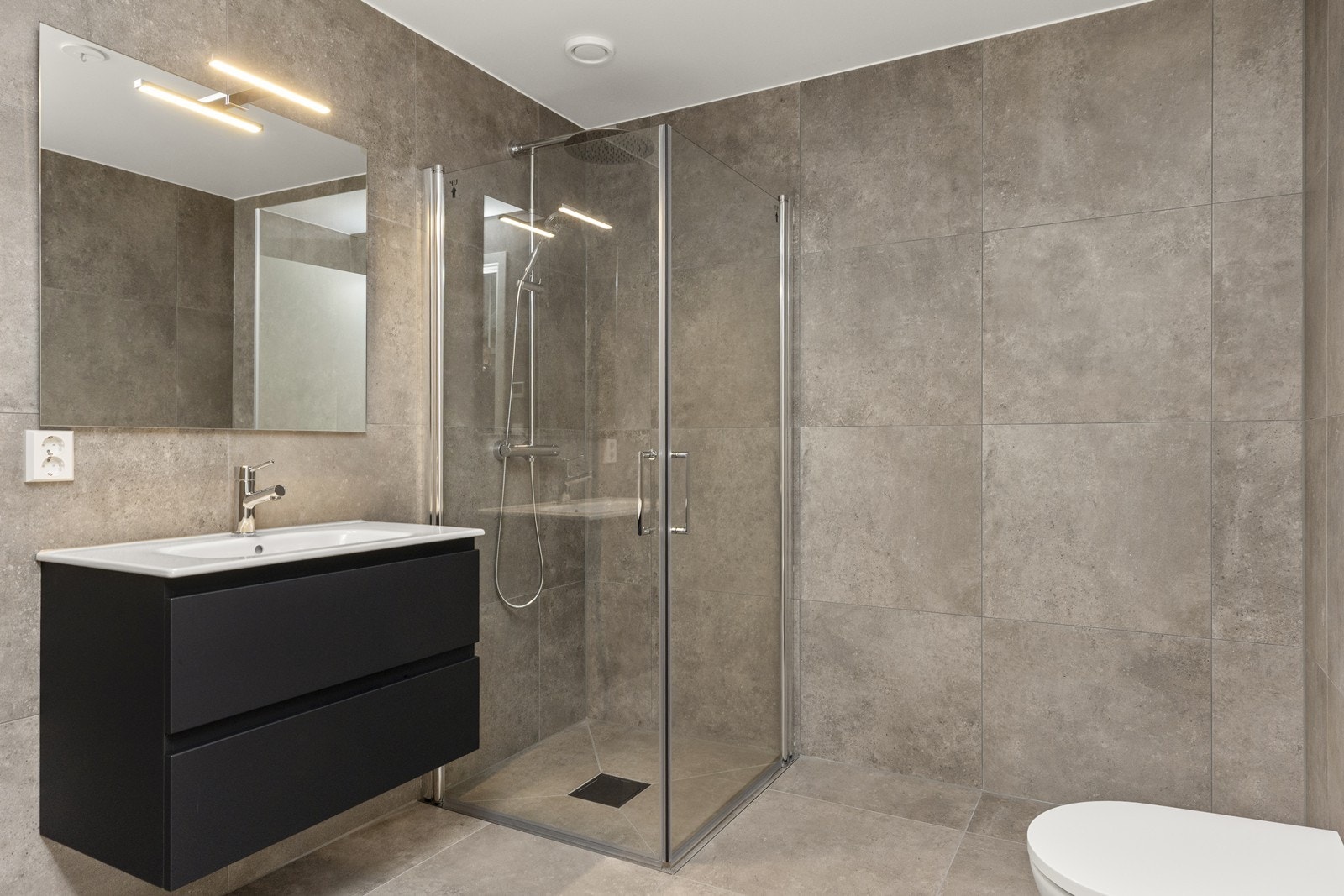 Meget delikat og innbydende bad i underetasjen, med fliser på gulv og vegger. Galleribilde