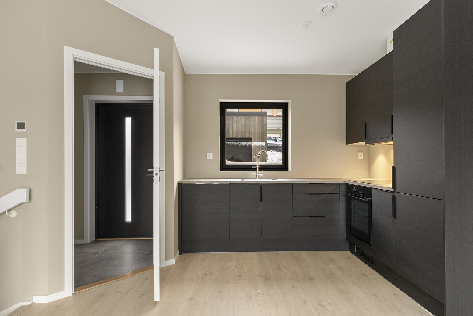 Fin innredning fra JKE som har har mørke, slette fronter og en slitesterk laminat benkeplate. Galleribilde