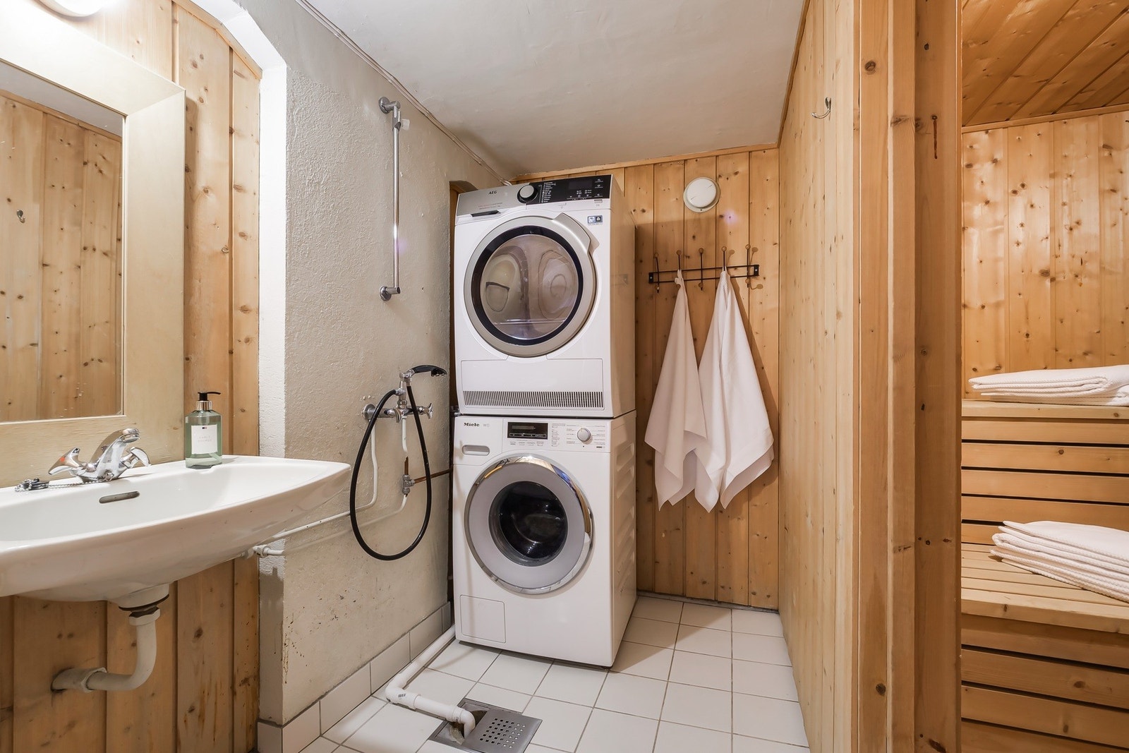 Vaskerom med flislagt gulv og varmekabler. Dette er utstyrt med dusj, servant og opplegg til vaskemaskin. Galleribilde
