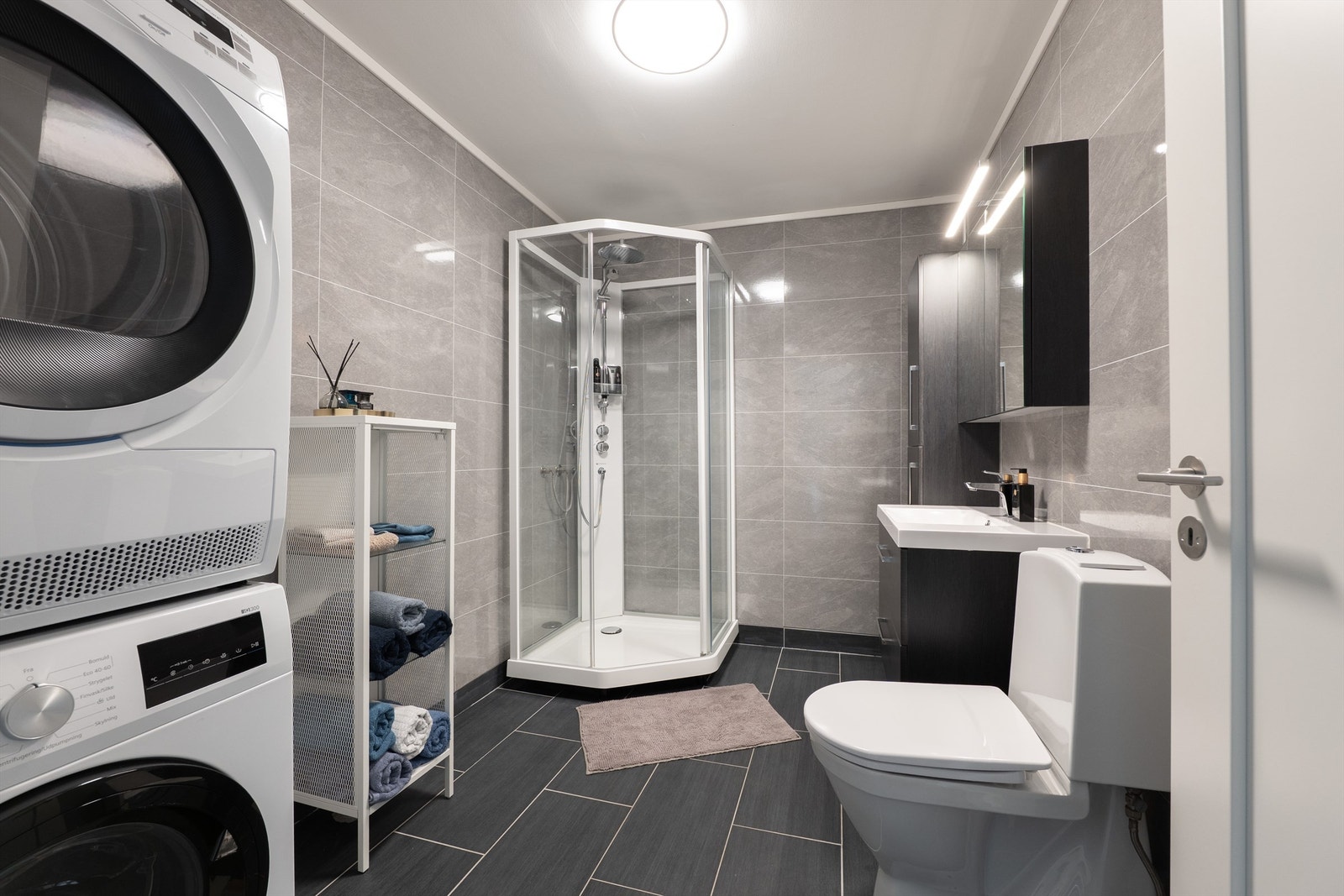 Badet har et moderne uttrykk med elektriske varmekabler og flislagt gulv. Galleribilde