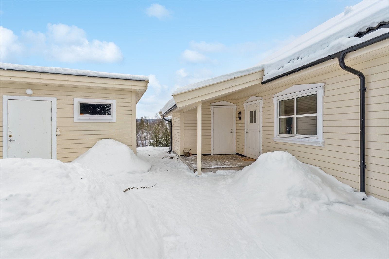 Overbygget inngangsparti som gir ly for vær og vind. Galleribilde