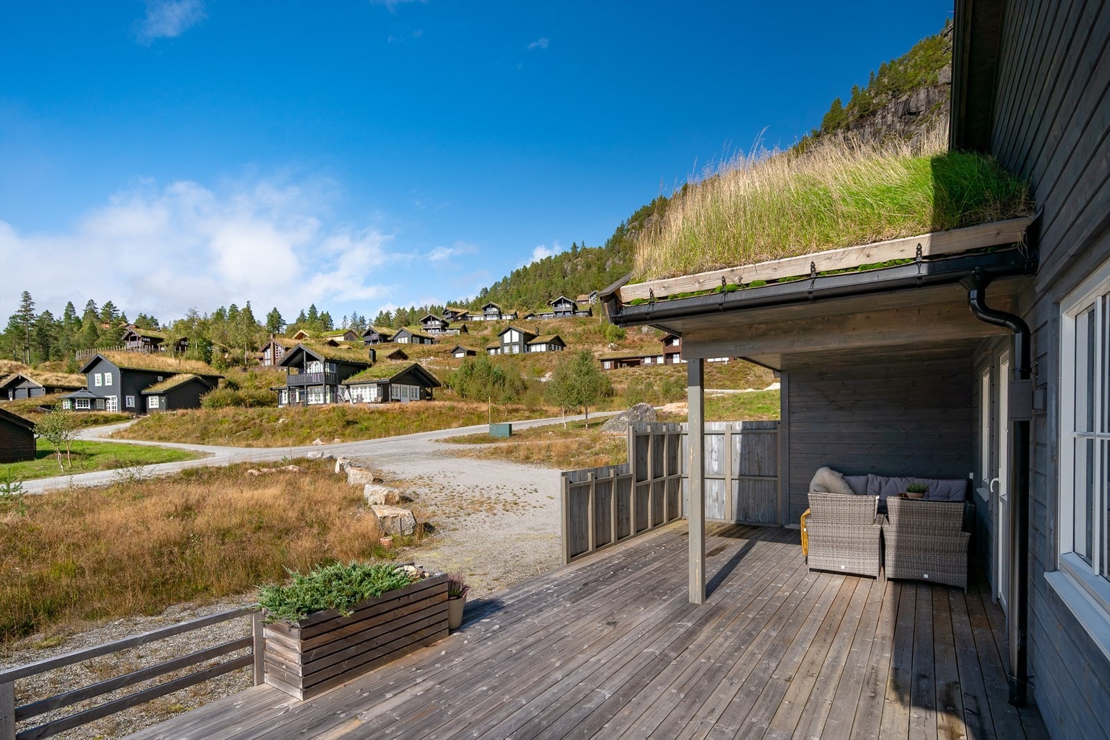 Skjermende levegg og delvis takoverbygg utenfor hovedsstuen Galleribilde