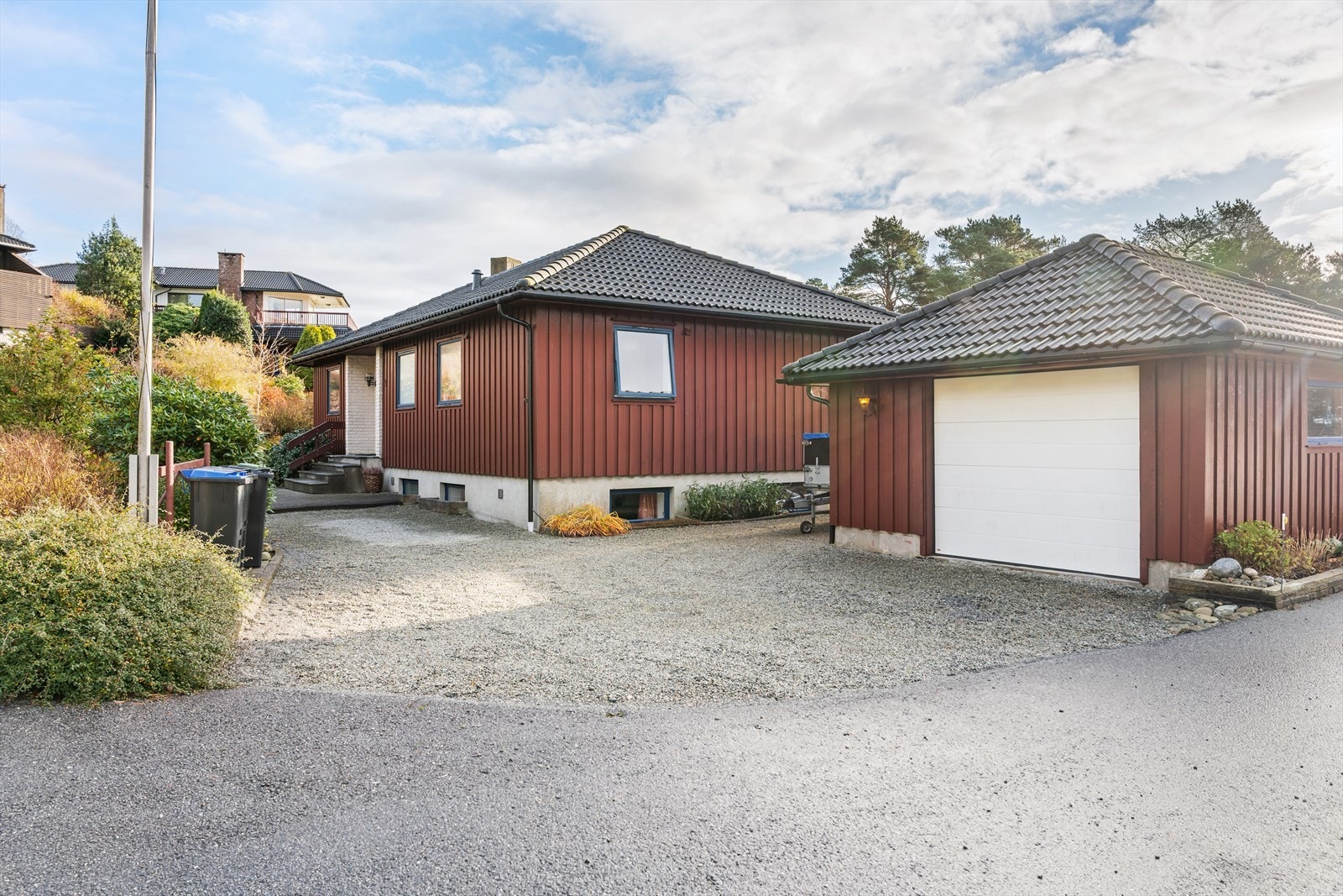 Gruset gårdsrom med parkeringsmuligheter og flaggstang. Galleribilde