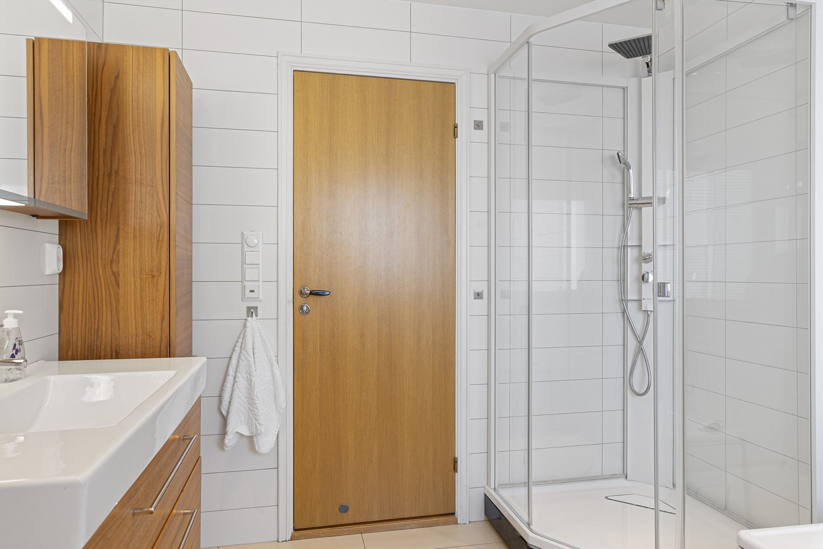 Badet inneholder tett dusjkabinett, badekar, seksjon med servant og vegghengt toalett. Galleribilde