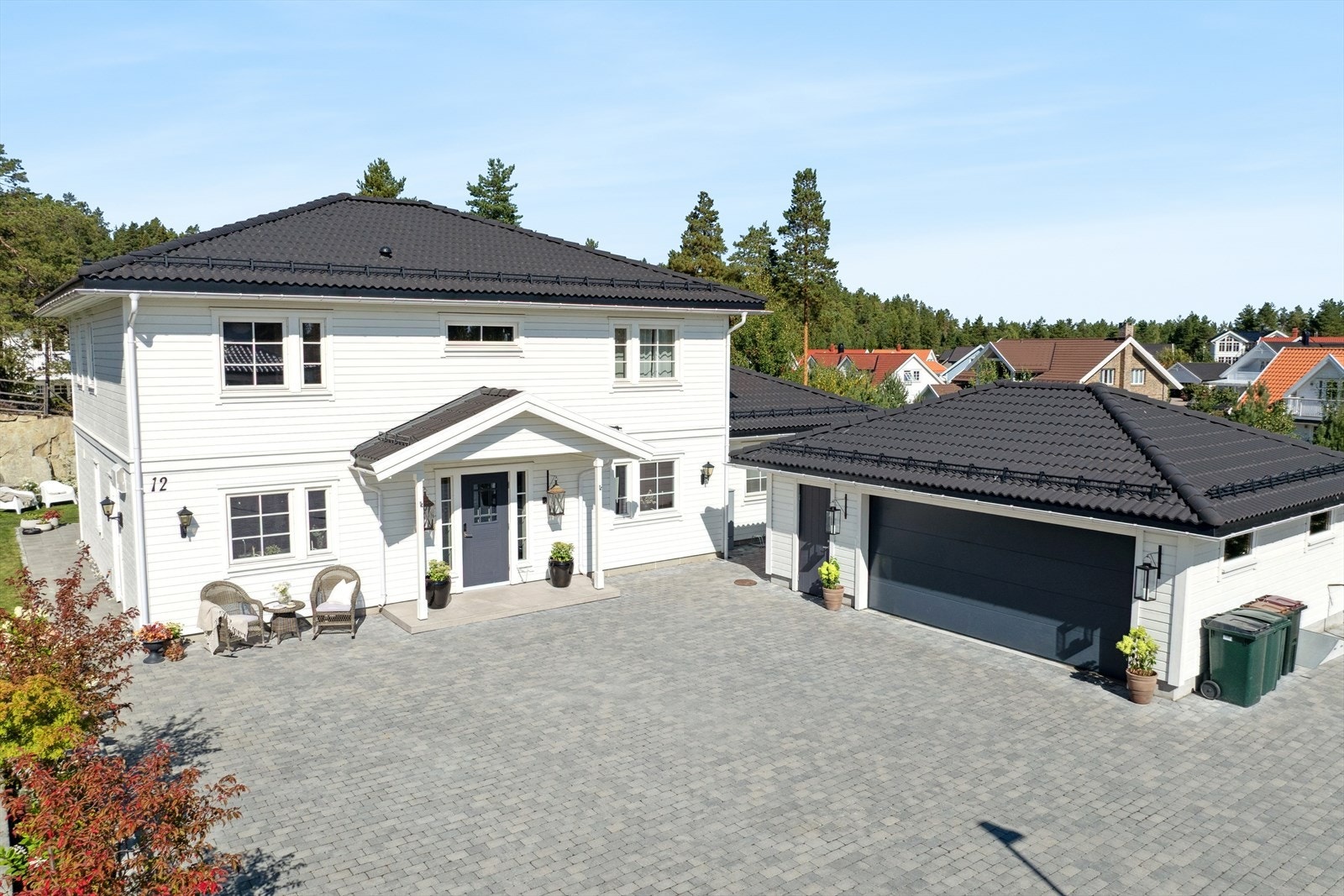 Eiendommen har en pen og velholdt fasade, med stor parkeringsplass og garasje. Galleribilde