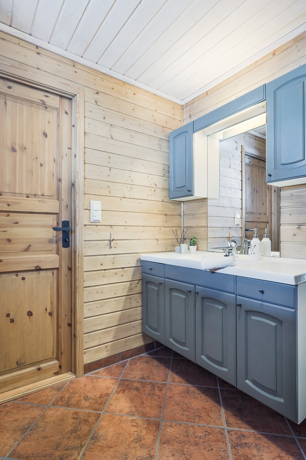 Badet er innredet med toalett, servant i baderomsmøbel og dusjkabinett. Galleribilde