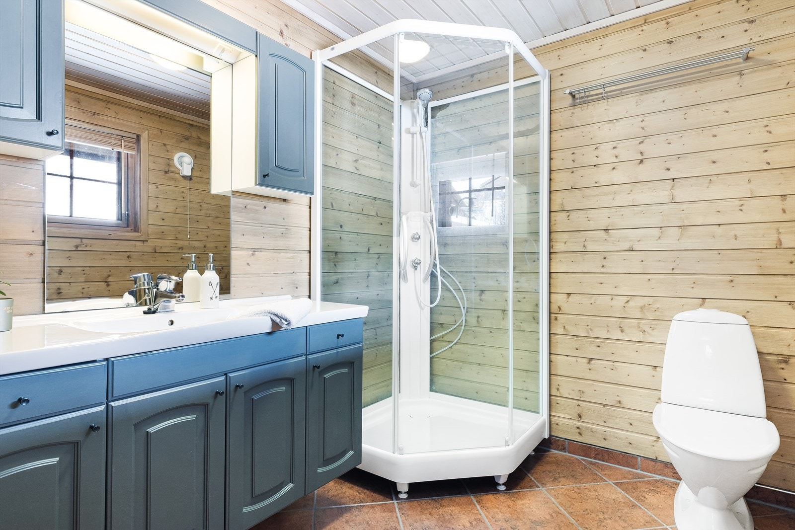 Badet har fliser på gulv og panel på vegger. Galleribilde