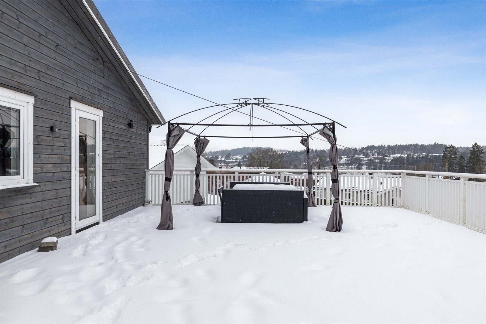 Stor terrasse med god plass til flere sittegrupper og med flott utsikt over nærområdet. Galleribilde