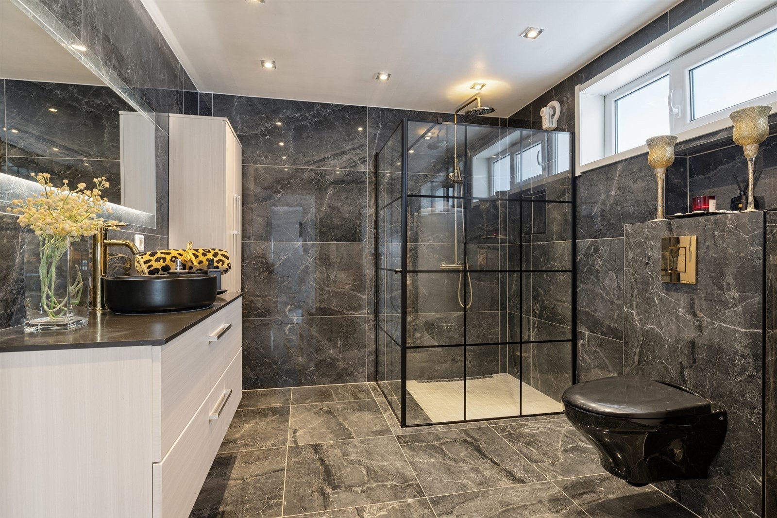 Det flislagte baderommet fra 2020 har et delikat uttrykk, med blant annet innfelt belysning i himlingen og opplegg for vaskemaskin. Galleribilde